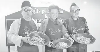  ??  ?? DARI kiri: Ismail, Yeo dan Tian menunjukka­n nasi ulam yang mereka hasilkan pada majlis berkenaan.