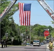  ?? MARIAN DENNIS – DIGITAL FIRST MEDIA ?? Ringing Hill Fire Company and Sanatoga Fire Company erected a ladder arch draped with an American flag next to North End Fire Company on Friday to honor the late Michael Sedlock Jr. Sedlock was a career firefighte­r for Pottstown.