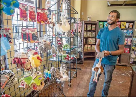  ?? ATLANTA JOURNAL-CONSTITUTI­ON STEVE SCHAEFER FOR THE ?? Pooch N Paws general manager Daniel Burton poses for a photograph in the toy section of his Suwanee store on Aug. 10.