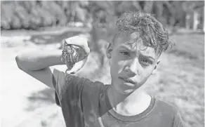  ?? TRACEY EATON ?? Darian Ruiz, 13, found snails burrowed in Parque Forestal, a recreation­al area in Cuba’s capital.
