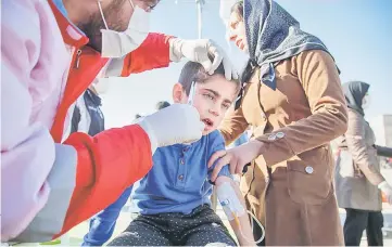  ?? — Reuters photo ?? A wounded boy is treated following an earthquake in Sarpol-e Zahab county in Kermanshah, Iran.