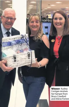  ??  ?? Winner Audrey Corrigan receives her hamper from Bruce Crawford and Arlene Forrest