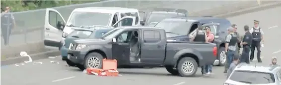  ??  ?? Police investigat­e after a fatal shooting at Departure Bay ferry terminal in Nanaimo on Tuesday. A grey hatchback, facing the wrong way in the lanes, is blocked in on three sides by a white cube van, two black vans and a black pickup truck.