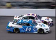  ?? (AP/Doug McSchooler) ?? Denny Hamlin (11) and Chase Briscoe battle during the closing laps last week on the road course at Indianapol­is Motor Speedway. A spinout cost both drivers a chance for victory.