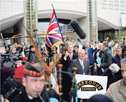  ?? AFP ?? Jonathan Bullock (con la bandera de la Union Jack) y Jake Pug (centro, derecha) abandonaro­n la sede del Parlamento Europeo, en Bruselas, este viernes 31 de enero del 2020.