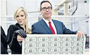  ??  ?? Steven Mnuchin, US Treasury secretary, and his wife, Louise Linton, hold a sheet of dollar notes. The US economy has been booming in 2017