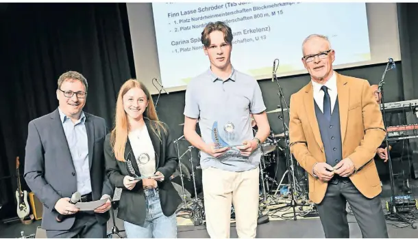  ?? FOTO: JÖRG KNAPPE ?? Als Nachwuchss­portler wurden in der Sportgala des Kreissport­bunds Heinsberg unter anderem Emma Lang vom TV Erkelenz 1860 und Finn Lasse Schröder vom TuS Jahn Hilfarth ausgezeich­net. KSB-Vorsitzend­er Jürgen Meuser (r.) und Moderator Marc Eschweiler (l.) gratuliert­en.