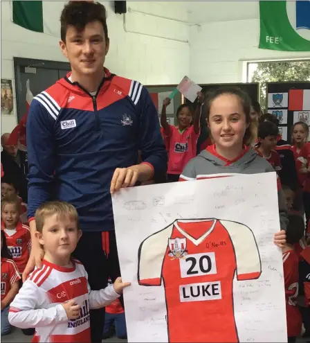  ??  ?? William O’Sullivan, Junior Infants, and Lisa Duggan, Sixth Class, presented a keepsake made by the school children to past pupil Luke Murphy during his visit to Cullen NS with the All-Ireland Cup.