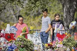  ??  ?? Mourners bring flowers as they pay tribute on Sunday at a memorial for the victims of the shooting at Marjory Stoneman Douglas High School.