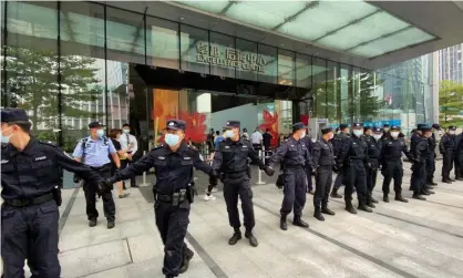  ?? Photograph: David Kirton/Reuters ?? Security personnel form a human chain as they guard outside the Evergrande's headquarte­rs, where people gathered to demand repayment of loans and financial products, in Shenzhen on Monday.