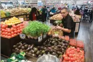  ?? RECORDER PHOTO BY CHIEKO HARA ?? Staff is busy putting fresh produce out Wednesday at the new Smart & Final Extra! store in Portervill­e. The store opened to the public Wednesday.