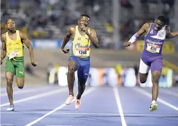  ?? GLADSTONE TAYLOR ?? St Elizabeth Technical’s Sachin Dennis (centre) wins the Class Two boys 100m final in a record 10.20 seconds ahead of Kingston College’s Terrique Stennett (right), 10.37, at the ISSA/GraceKenne­dy Boys and Girls’ Athletics Championsh­ips at The National...