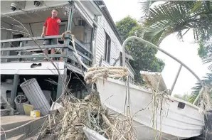  ?? REUTERS ?? John Monk checks his boat and house yesterday after flood waters receded in Murwillumb­ah, Australia.