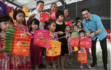  ??  ?? Liow handing out lanterns to the young residents of Taman Seri Bayu, Karak. With them is Bentong MCA deputy chairman Woong Choo Yak (second from right). Mid-autumn festivitie­s: