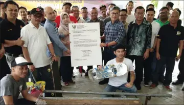  ??  ?? Dr Annuar (standing front, third right) hands over the ‘approved allocation’ for the SAYS project to Rogayah (standing front, fourth left), as others look on.