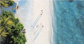 ?? — AFP ?? Beach paradise: an aerial photo of people walking along a beach in Vilimalé Island in the Maldives. The Indian Ocean nation, which has traditiona­lly been close to neighbour India, has recently pivoted towards China under Muizzu.