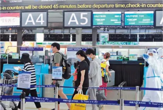  ?? — CFP ?? The first batch of COVID-trapped tourists check in at Sanya Phoenix Internatio­nal Airport in Sanya, Hainan Province, yesterday. Tourists from outside the south China island began returning home yesterday.