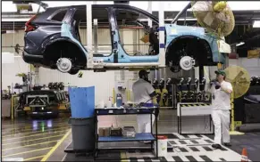  ?? CANADIAN PRESS FILES ?? Honda workers assemble a CRV on the production line at the vehicle maker’s plant in Alliston last April.