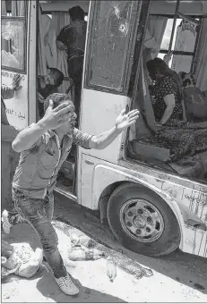  ?? AP PHOTO ?? A man screams beside a bus carrying Coptic Christians which came under attack outside Cairo, Friday. Islamic militants on Friday ambushed a bus carrying Christian pilgrims on their way to a remote desert monastery south of the Egyptian capital, killing at least seven and wounding a dozen more, the Interior Ministry said.