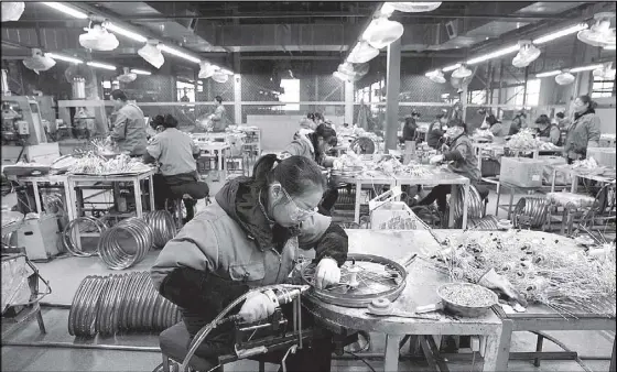  ?? REUTERS ?? Employees work on the production line of Kent bicycles at Shanghai General Sports Co. Ltd. in Kunshan, Jiangsu Province, China.