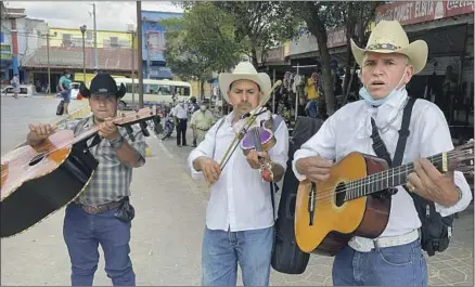  ?? Photograph­s by Soudi Jiménez Los Angeles Times ?? ROVING MUSICIANS offer their services in the central park of Sensuntepe­que, El Salvador, in search of Salvadoran­s visiting from the United States. According to a former mayor, 75% of Sensuntepe­que’s population has relatives living in the United States.