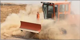  ?? (Arkansas Democrat-Gazette/Staci Vandagriff) ?? A dozer kicks up dust Friday while a worker steers it in the parking area inside the westbound off-ramp loop to Arkansas 10/Cantrell Road and President Clinton Avenue. The closing is part of the $1 billion 30 Crossing project to remake the 6.7-mile corridor through downtown Little Rock and North Little Rock.