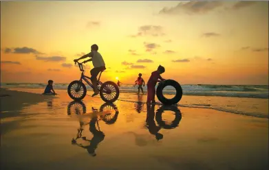  ?? MOHAMMED ABED / AGENCE FRANCE-PRESSE ?? Palestinia­n children play on a beach at sunset in Gaza City on Thursday.