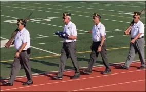  ?? RECORDER PHOTO BY ESTHER AVILA ?? The color guard from American Legion Post 20 walk down the track during the 2021 Buck Shaffer Band-a-rama at Jacob Rankin Stadium.