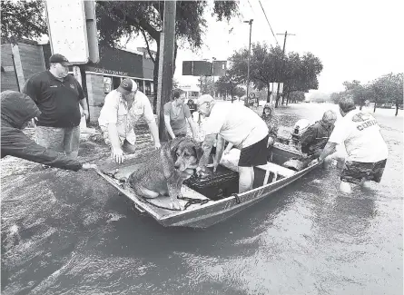  ?? FILE ?? Neighbours use their personal boats to rescue flooded residents in Texas.