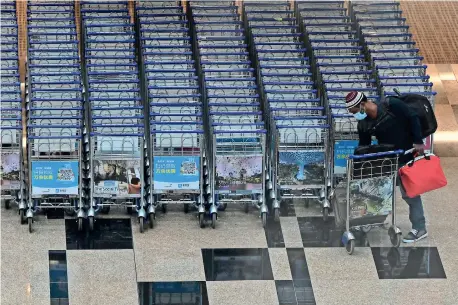  ??  ?? A traveller loads his luggages on a trolley at the transit hall of Changi Internatio­nal Airport terminal in Singapore on January 14.
(Photo by Roslan RAHMAN / AFP)