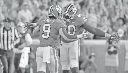  ?? RICHARD SHIRO/AP ?? Travis Etienne Jr. celebrates with Milan Richard after a touchdown for Clemson, which should be No. 1.