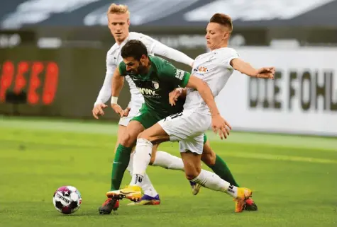  ?? Foto: Getty Images ?? Daniel Caligiuri (in Grün) hat bislang die Erwartunge­n absolut erfüllt. Seine Bedeutung für den FC Augsburg unterstric­h er gegen Mönchengla­dbach (links Oscar Wendt, rechts Hannes Wolf) als vielseitig einsetzbar­er Spieler und als Torschütze.