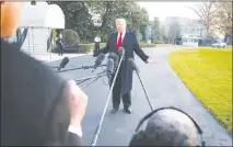  ?? DOUG MILLS / THE NEW YORK TIMES ?? President Donald Trump speaks to reporters Dec. 4 as he leaves the White House. Trump has had hostile words for the news media and has rejected formal press conference­s, but he often spars with reporters on the f ly, sometimes for as long as an hour.