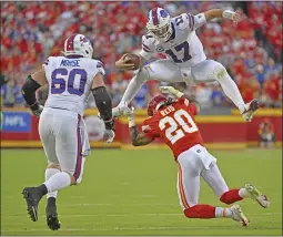  ?? PETER AIKEN – THE ASSOCIATED PRESS ?? Bills quarterbac­k Josh Allen hurdles Chiefs safety Justin Reid during Sunday's game in Kansas City, Mo. Allen passed for 329yards and three touchdowns in Buffalo's win.