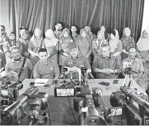  ?? — Gambar Bernama ?? KELUARPART­I:Hamzah(duduk, tiga kiri) ketika sidang akhbar mengenai lebih 50 ahli Parti Pribumi Bersatu Malaysia (PPBM) Bahagian Larut mengumumka­n keluar parti dan menyertai UMNOdi Larut, semalam.