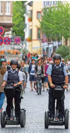  ??  ?? FOTO: PATRICK SEEGER/DPA Die Polizisten Janka Schmidt und Matthias Engler fahren für mehr Nähe zu den Bürgernauf ihren Segways duch die Freiburger Innenstadt.