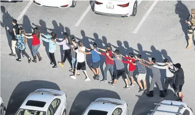  ?? Pictures: Getty Images. ?? Pupils and staff being led to safety following the shooting attack.