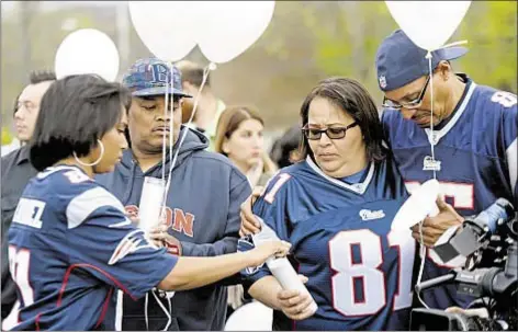  ??  ?? Mourners gather near football field in Connecticu­t on day of funeral of former Patriots tight end Aaron Hernandez, who killed himself last week in prison cell he was serving life sentence in following murder conviction three years ago.