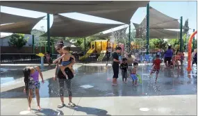  ?? RECORDER PHOTOS BY CHIEKO HARA ?? Refreshing scenes from the Splash Pad at Fallen Heroes Park as residents cool off (above) and Caylee Redwine (right) wets her hair Saturday, July 14. Community members now can enjoy the Splash Pad from 4 p.m. to 6 p.m. on weekdays and from 3p.m. to 5p.m. on weekends.