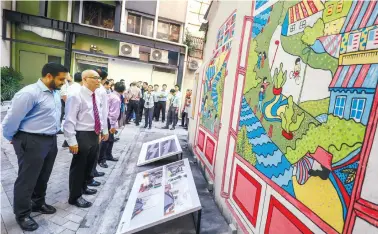  ??  ?? ... Kuala Lumpur Mayor Datuk Nor Hisham Ahmad Dahlan (second from left) looking at a mural at Lorong Bandar 13, which is part of the laneway upgrading programme in the city. Eight laneways within the historic core of Kuala Lumpur have been identified to be part of the upgrading project