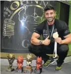  ??  ?? RISING STAR: Johnny Moutzouris of Johnny’s Gym in Komani with the trophies he won during recent body building competitio­ns