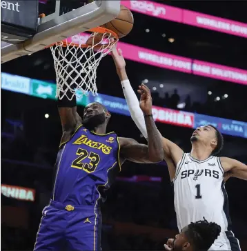  ?? MARCIO JOSE SANCHEZ — THE ASSOCIATED PRESS ?? Lakers forward LeBron James battles Spurs rookie center Victor Wembanyama for a rebound in Friday night's win.