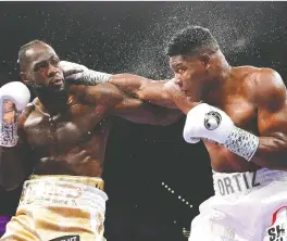  ?? STEVE MARCUS/GETTY IMAGES ?? WBC heavyweigh­t champion Deontay Wilder, left, trades punches with Luis Ortiz during their title fight at MGM Grand Garden Arena on Saturday in Las Vegas. Wilder won to retain his title with a seventh-round knockout, setting up a rematch with Tyson Fury.