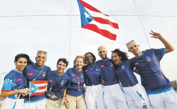  ?? Andre kang / enviado especial ?? Miembros de la delegación de Puerto Rico posan frente a la bandera en la Villa Centroamer­icana.