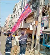  ?? — DC ?? Officials remove political banners and hoardings in line with the election code, on Sunday.