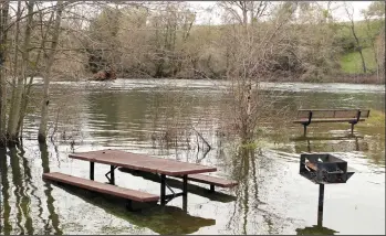  ?? JERRY R. TYSON/COURTESY PHOTOGRAPH ?? Picnic essentials at the Mokelumne Fish Hatchery are underwater Monday afternoon as the dam releases 5,000 cubic feet of water per second.