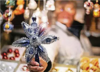  ?? RP-FOTO: STEPHAN KÖHLEN ?? Am Stand von Helga Fischer gibt es Thüringer Christbaum­schmuck. Sie kann jeden Wunsch nach Glitter, Glitzer und Flimmer erfüllen – und das in allen Farben. Im Bild: ein Stern für die Tannenspit­ze.