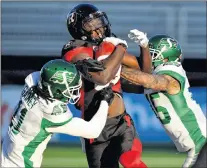  ?? CP PHOTO ?? Ottawa Redblacks’ Dominique Rhymes (centre) fends off Saskatchew­an Roughrider­s’ Ed Gainey (left) and Kacy Rodgers II during second half Eastern semifinal CFL action in Ottawa on Sunday.