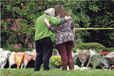  ?? MATT ROURKE/AP ?? Mourners support each other Sunday at a makeshift memorial at the Tree of Life Synagogue in Pittsburgh.