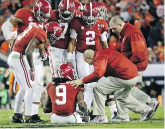  ?? DAVID J. PHILLIP/THE ASSOCIATED PRESS FILES ?? Alabama’s Bo Scarbrough is examined after being hurt during an NCAA college football game last season.